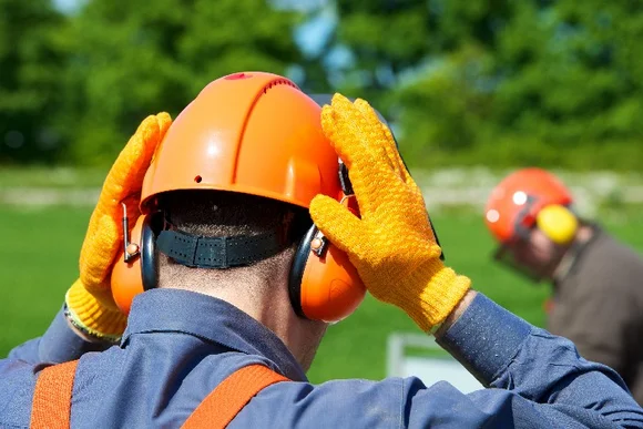 Person setzt Gehörschutz auf
